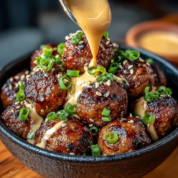 A bowl of meatballs with spicy mayo dip.