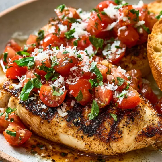 A plate of chicken with tomatoes and basil.