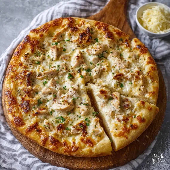 A pizza with chicken alfredo toppings.