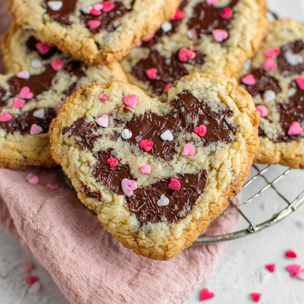 A plate of heart shaped chocolate chip cookies.