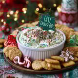 A white bowl filled with a creamy dip sits on a table.