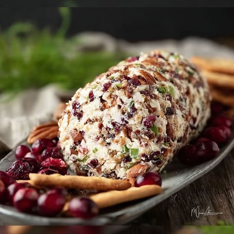 A cranberry pecan cheese ball on a plate.