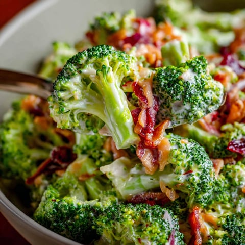 A bowl of broccoli salad with bacon.