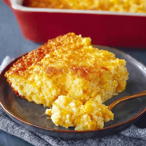 A slice of corn casserole on a plate.