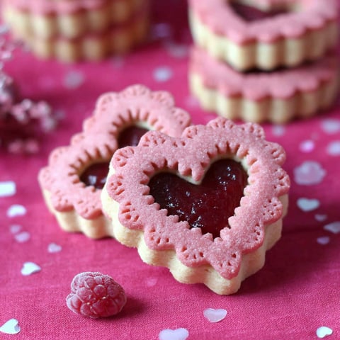 A heart shaped biscuit with jam in it.
