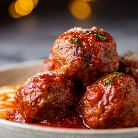 A plate of meatballs with tomato sauce.